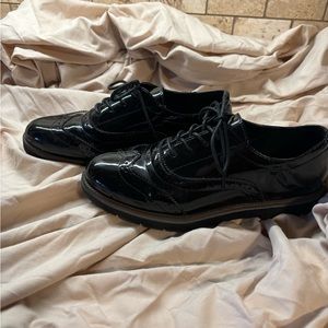 Loafer black patent leather like shoes.